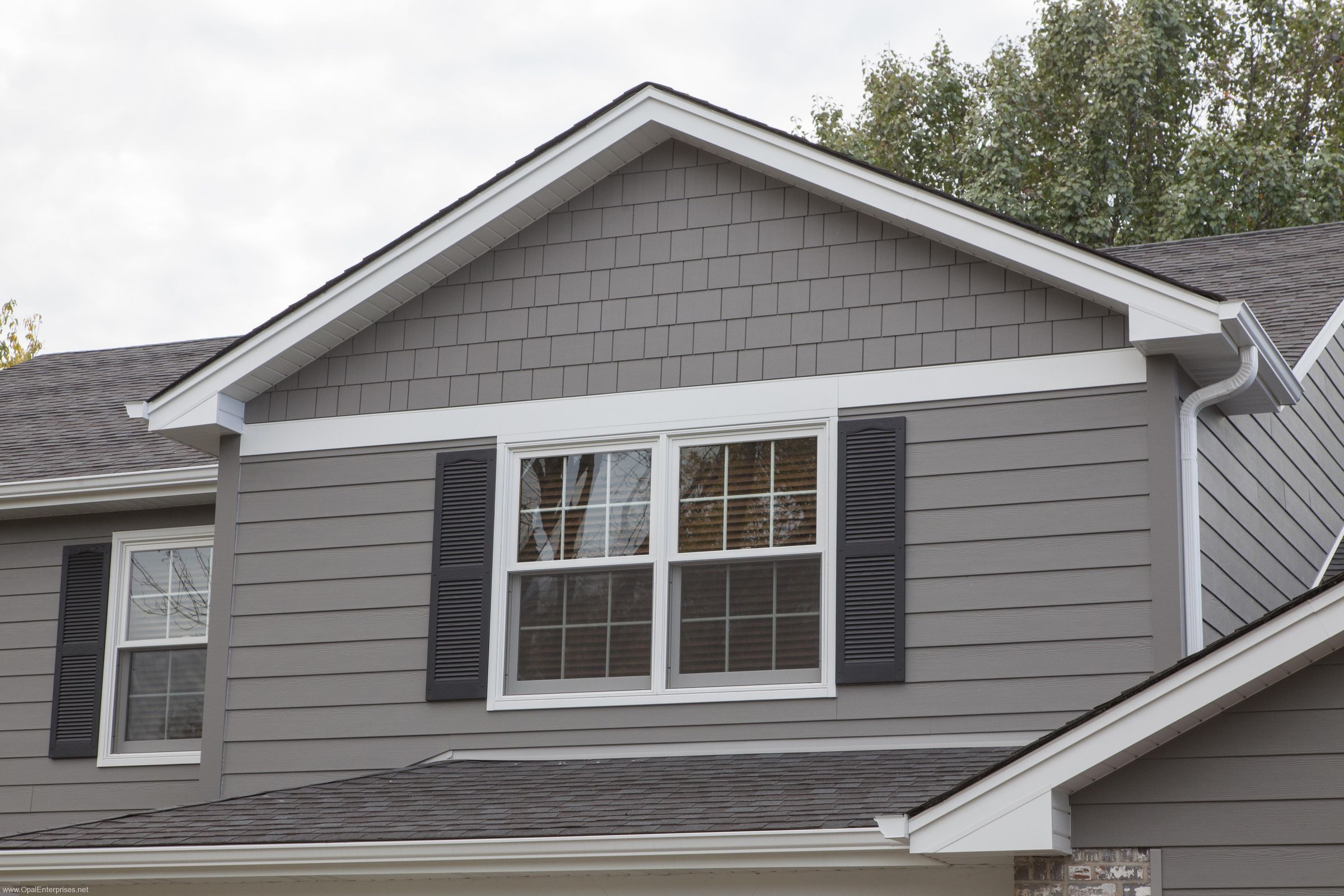 Finished gray siding and windows on a residential exterior